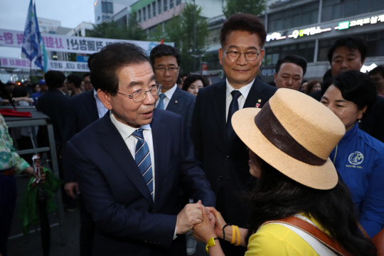 17일 더불어민주당 박원순 서울시장 후보가 광주 동구 금남로에서 열린 5·18 민주화운동 38주년 전야제에 참석하며 시민과 악수하고 있다. 연합뉴스.